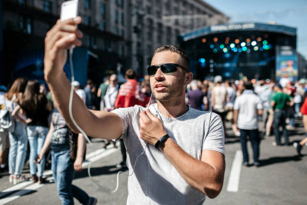 A young boy is a coverage of a sporting event, or a concert. A blogger is using a smartphone to go live. A journalist is a calling.