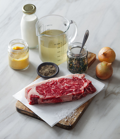 Raw fresh beef steak with ingredients for classic mustard and green peppercorn sauce