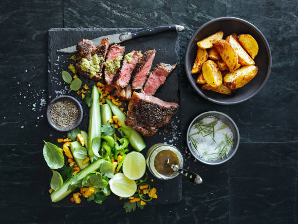 French pepper steak (Steak au Poivre) with fresh vegetables and herbs French pepper steak (Steak au Poivre) with fresh vegetables and herbs on dark background steak salad stock pictures, royalty-free photos & images