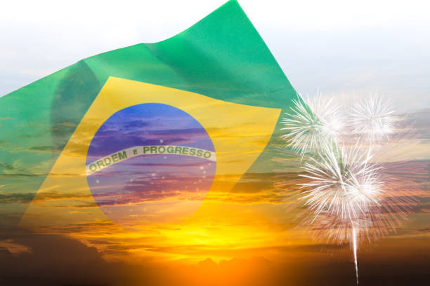 Brazil independence day, 7th september, double exposure waving Brazil flag and sunset sky with fireworks stock photo