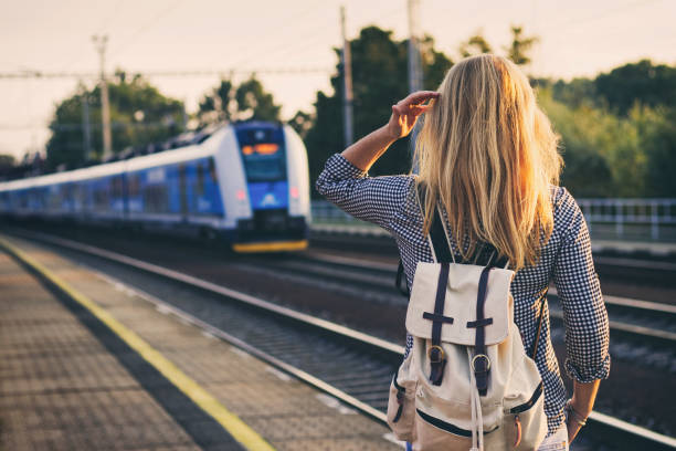 istock Woman is looking at arriving train at a railway station. 1013175884
