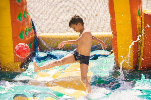 istock Boy kicking ball in inflatable foam pool 1013204992