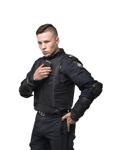 Police officer in black uniform and body armor on white background. Policeman in special ammunition