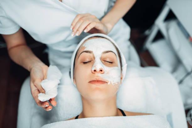 istock Beautician hands with cream against patient face 1013213284
