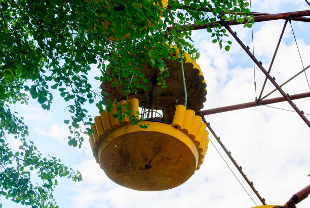 Observation wheel carousel with yellow cabins in the former musement park in Pripyat, a ghost town in northern Ukraine, evacuated the day after the Chernobyl disaster on April 26, 1986