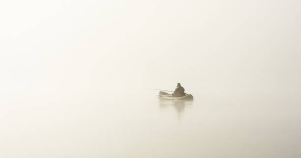 istock fisherman in boat in fog 1013234428