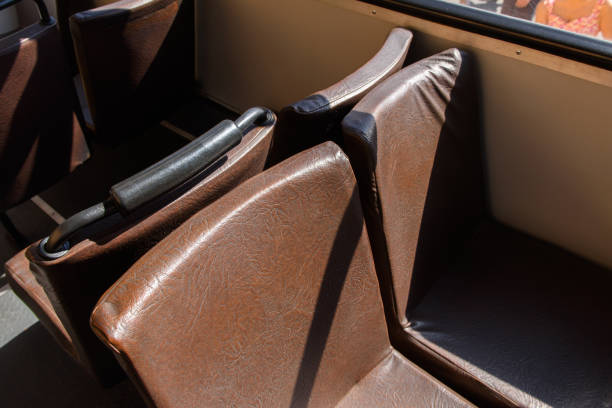 istock Brown seats in a yellow Soviet Russian old fashioned passenger bus. 1013268544