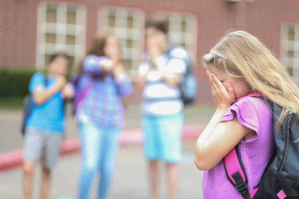 istock Elementary age girl being bullied at school. 1013275076