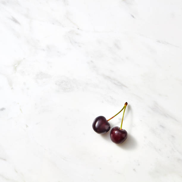 istock Red sweet cherries on a marble background with copy space. 1013280496
