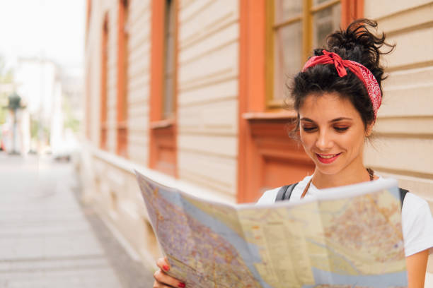 istock Smiling young woman looking at touristic map 1013299928