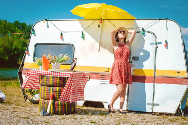 istock hippie female standing next to the car trailer 1013311268