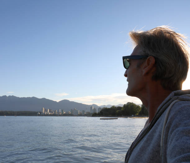 istock Man looks out to city skyline and sea 1013329310