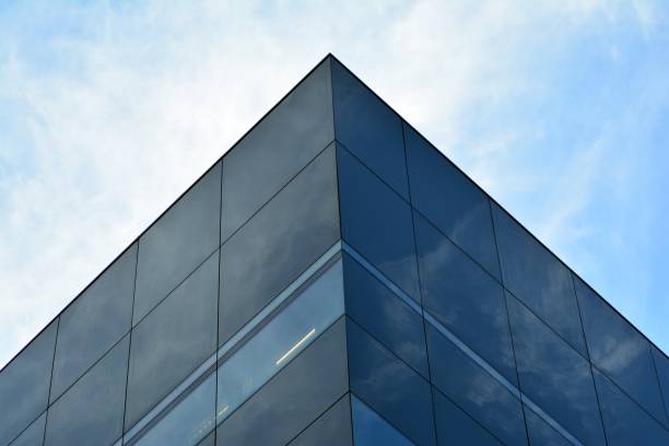 istock Sky and clouds reflecting on a building with mirrored glass 1013339738