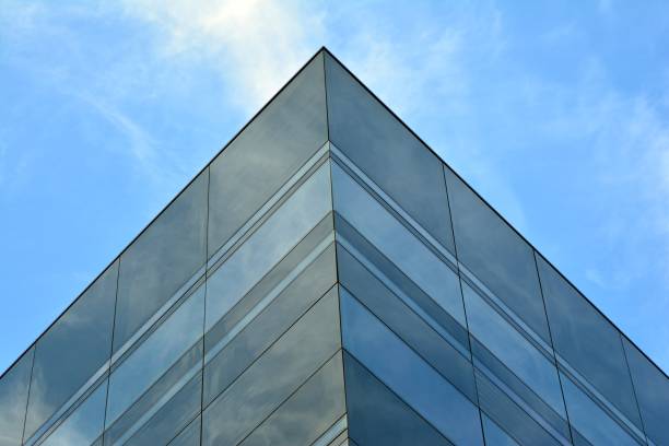 istock Sky and clouds reflecting on a building with mirrored glass 1013339858