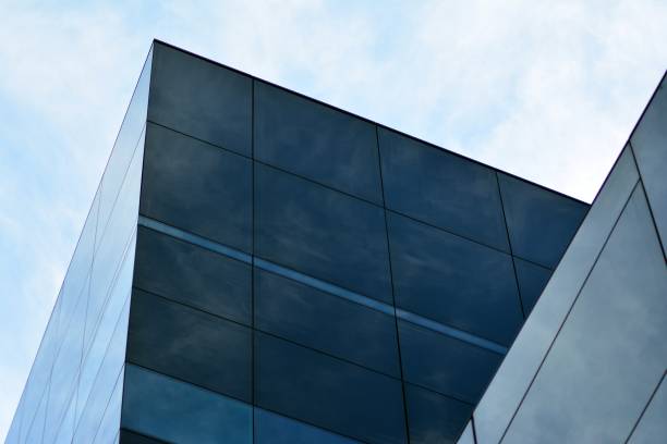 istock Sky and clouds reflecting on a building with mirrored glass 1013340104