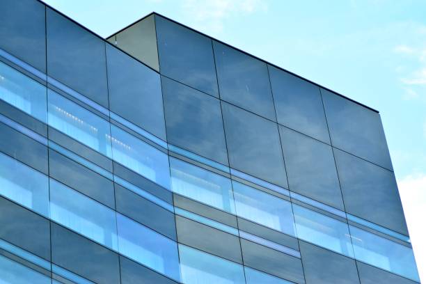 istock Sky and clouds reflecting on a building with mirrored glass 1013340220