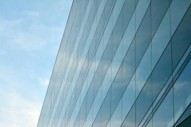 istock Sky and clouds reflecting on a building with mirrored glass 1013340252