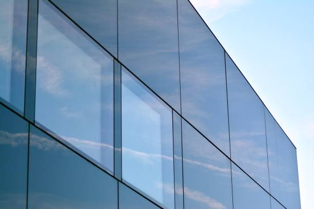 istock Sky and clouds reflecting on a building with mirrored glass 1013340276