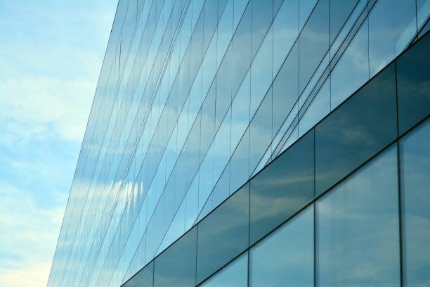 istock Sky and clouds reflecting on a building with mirrored glass 1013342458