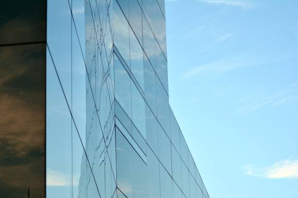 istock Sky and clouds reflecting on a building with mirrored glass 1013342598