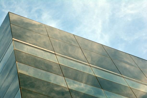 istock Sky and clouds reflecting on a building with mirrored glass 1013342632
