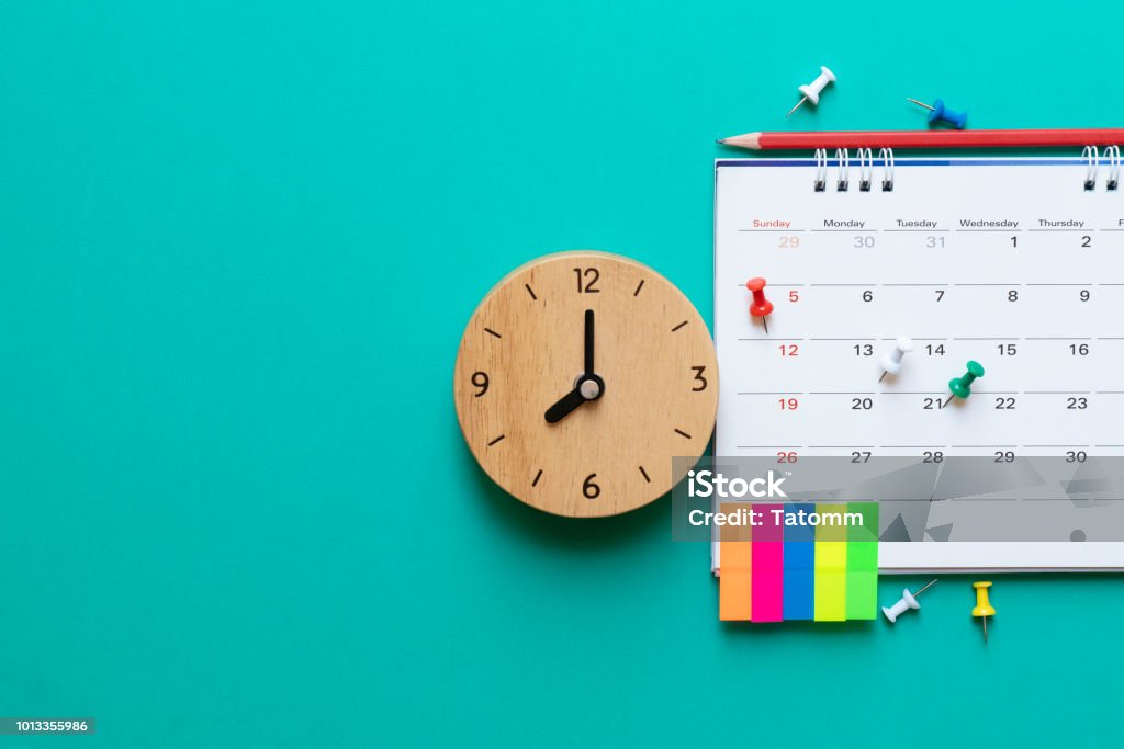 close up of calendar and clock on green background, planning for business meeting or travel planning concept Time Stock Photo