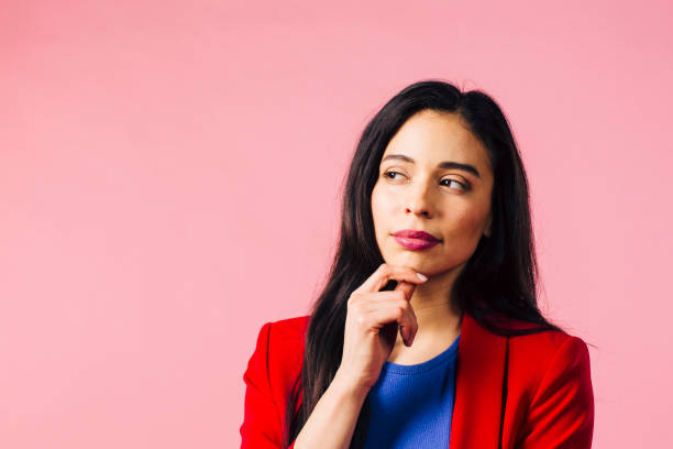 istock Thinking about it, portrait of a young brunette in red jacket looking left 1013371628