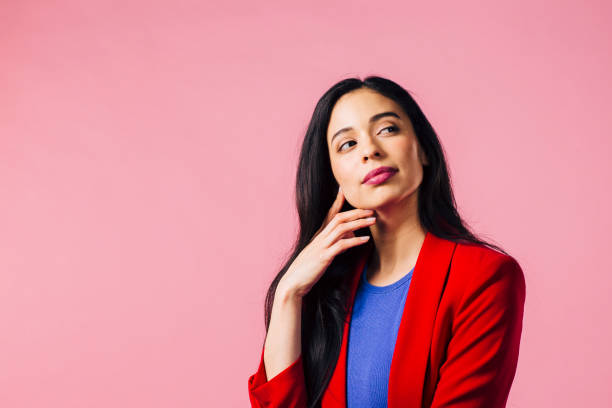 istock Curious brunette contemplating something, wearing red jacket and looking up and off camera 1013371632