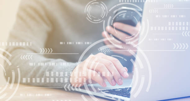Close up businessman hand typing or working on laptop and smart phone for programming about cyber security with virtual interface protection circle wheel interface, advance future technology concept