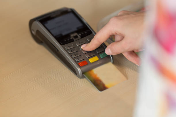 istock Hand with credit card swipe through terminal for payment in cafe. 1013416538