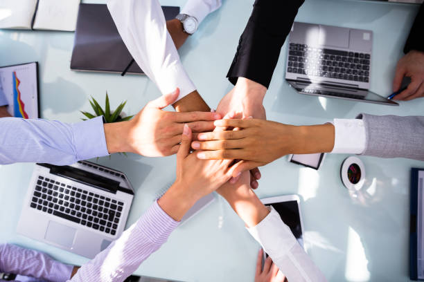 istock Group Of Businesspeople Stacking Hands 1013419410