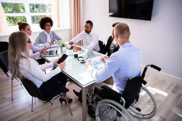 istock Disabled Manager Sitting With His Colleagues 1013419464