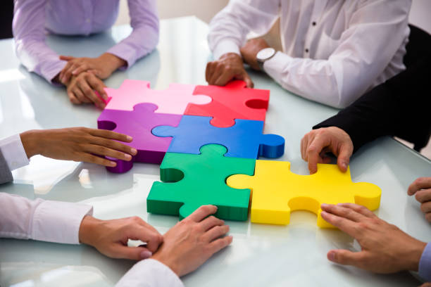 istock Group Of Businesspeople Solving Jigsaw Puzzle 1013419608