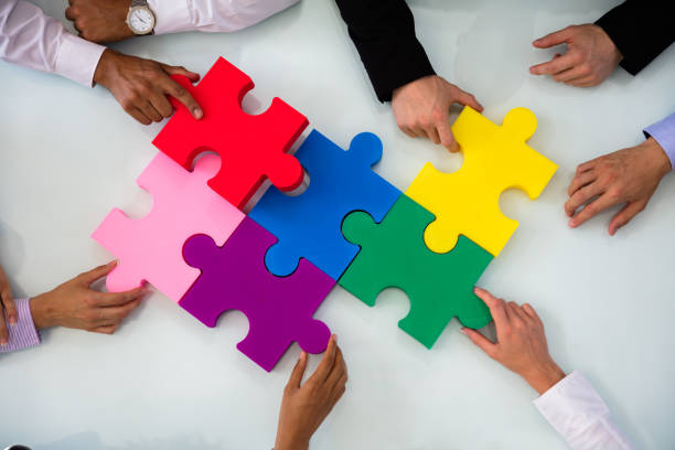 istock Group Of Businesspeople Solving Jigsaw Puzzle 1013419610