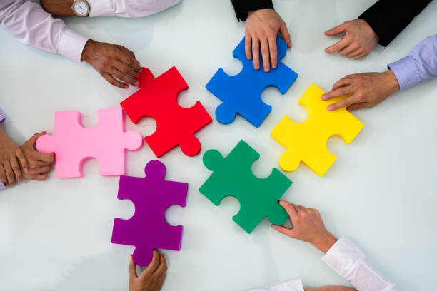 istock Group Of Businesspeople Solving Jigsaw Puzzle 1013419620