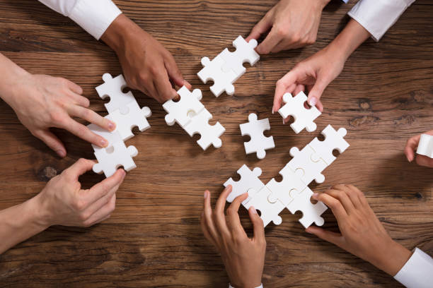 istock Businesspeople Solving Jigsaw Puzzle Together 1013419862