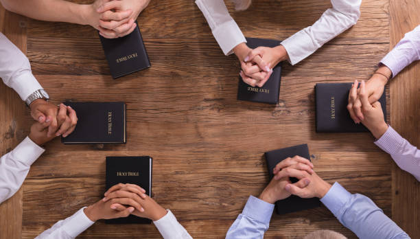 istock People's Praying Hands On Holy Bible 1013419914