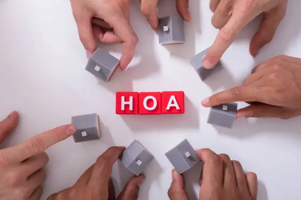 Homeowner Association Blocks Surrounded By People Holding House Model On White Surface