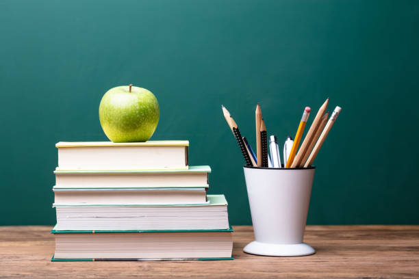 istock Green Apple On Top Of Stacked Books 1013427748