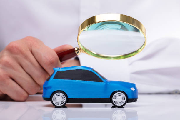 istock Businessman Holding Magnifying Glass Over Car 1013435008