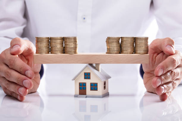 istock Businessman Protecting Stacked Coins On Seesaw 1013435190