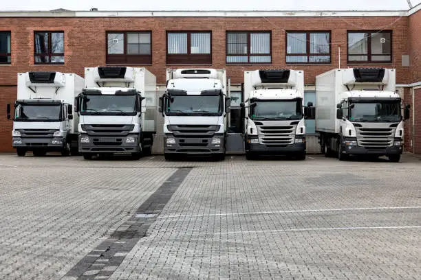 row of trucks next to each other in front of a warehouse