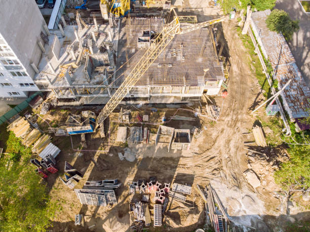 istock aerial view of building under construction and tower crane 1013440690