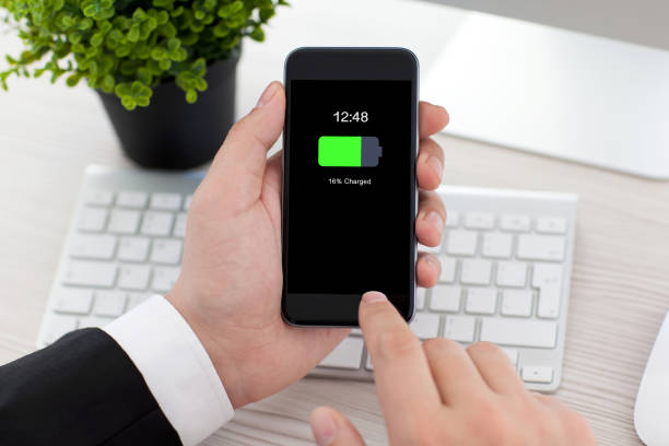 istock man in office holding phone with charged battery on screen 1013445342