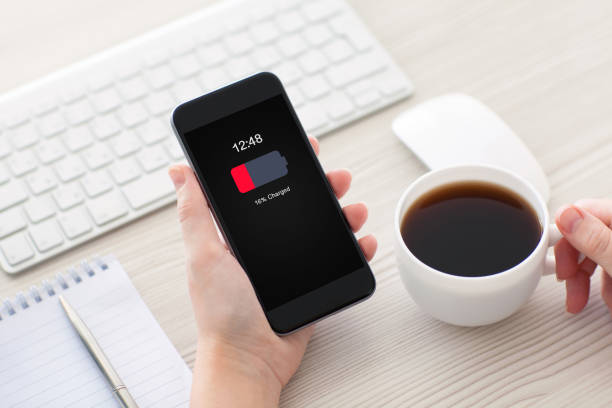 istock Women hands holding phone with low charged battery on screen 1013445396