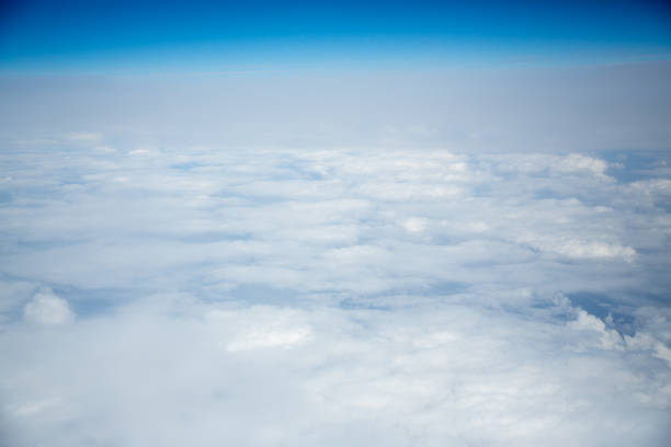 istock Clouds and sky as seen through window of an aircraft 1013452656