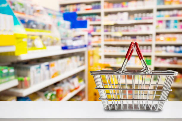 Empty shopping basket on pharmacy drugstore counter with blur shelves of medicine and vitamin supplements background Empty shopping basket on pharmacy drugstore counter with blur shelves of medicine and vitamin supplements background over the counter meds stock pictures, royalty-free photos & images