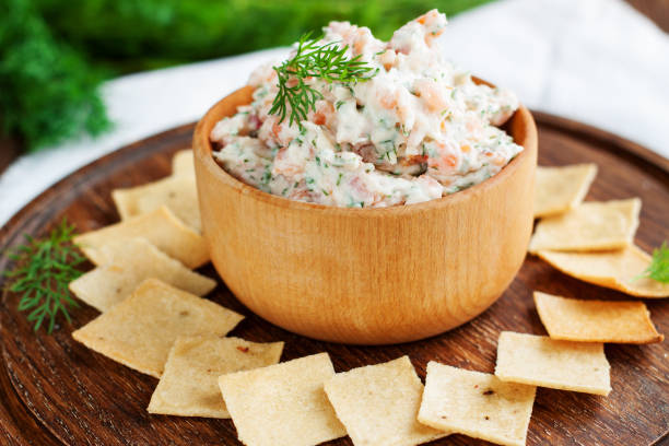 Smoked salmon and cream cheese dip with crackers Smoked salmon, cream cheese and dill dip in wooden bowl served with gluten free crackers on round cutting board tuna pate stock pictures, royalty-free photos & images