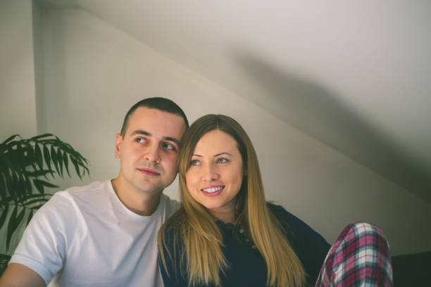 istock Happy couple relaxing together on their bed 1013466302
