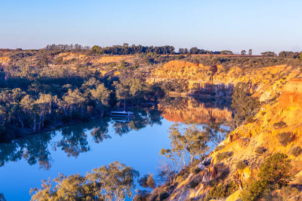 istock Sandstone eroding cliffs over houseboat moored in Murray River at sunset. Riverland, South Australia 1013480008